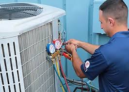 Technician checking manifold pressure gauges on an outdoor cooling unit